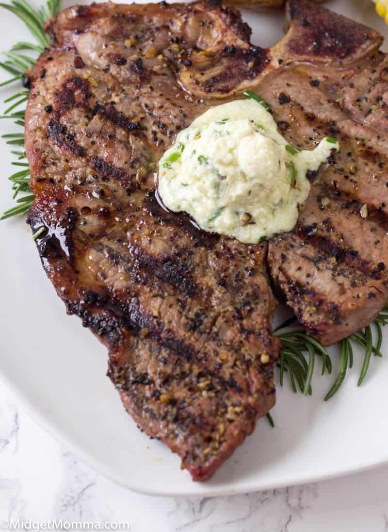 Grilled Steak on a white plate topped with blue cheese butter