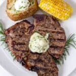 Grilled Steak on a white plate topped with blue cheese butter compound