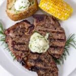 Grilled Steak on a white plate topped with blue cheese butter compound