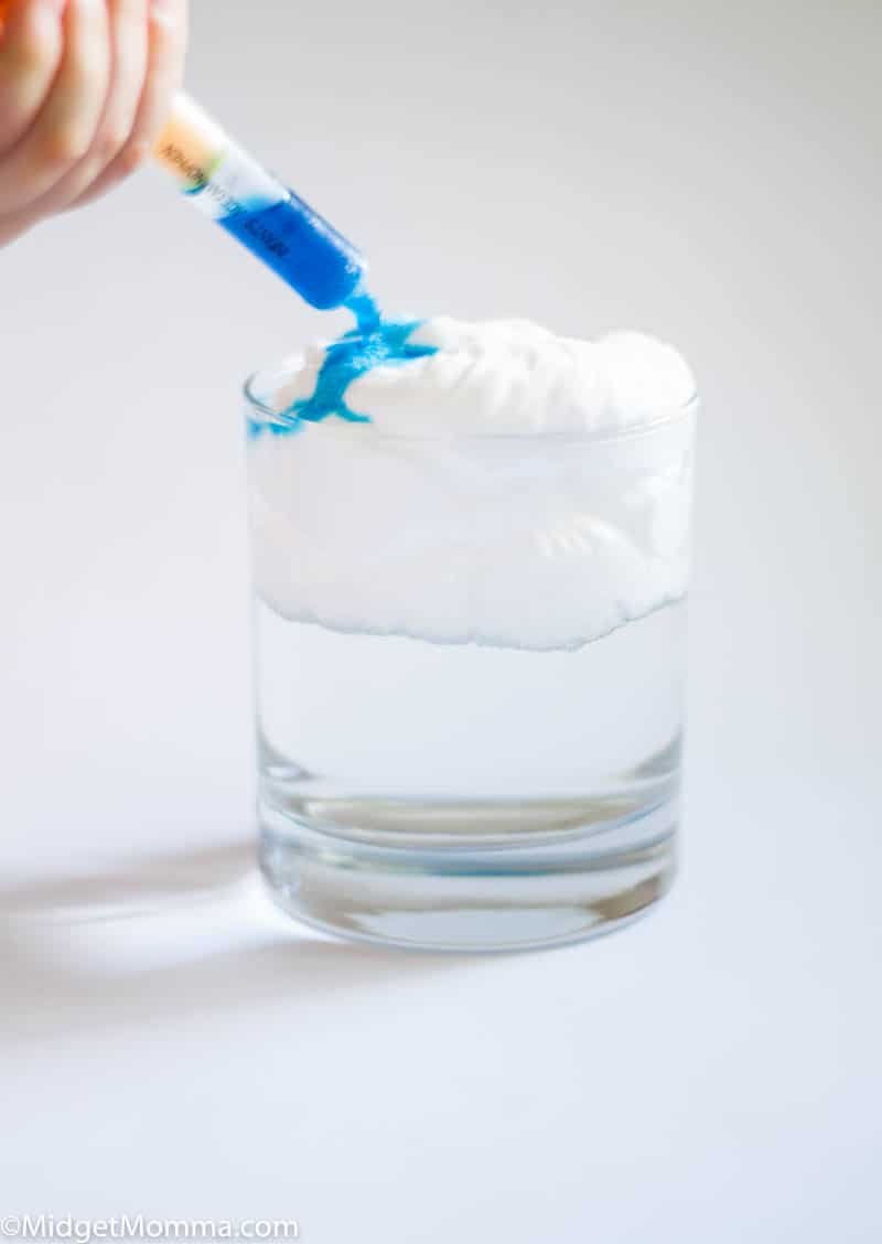 Rain Cloud science experiment- dropper with blue water being added to shaving cream