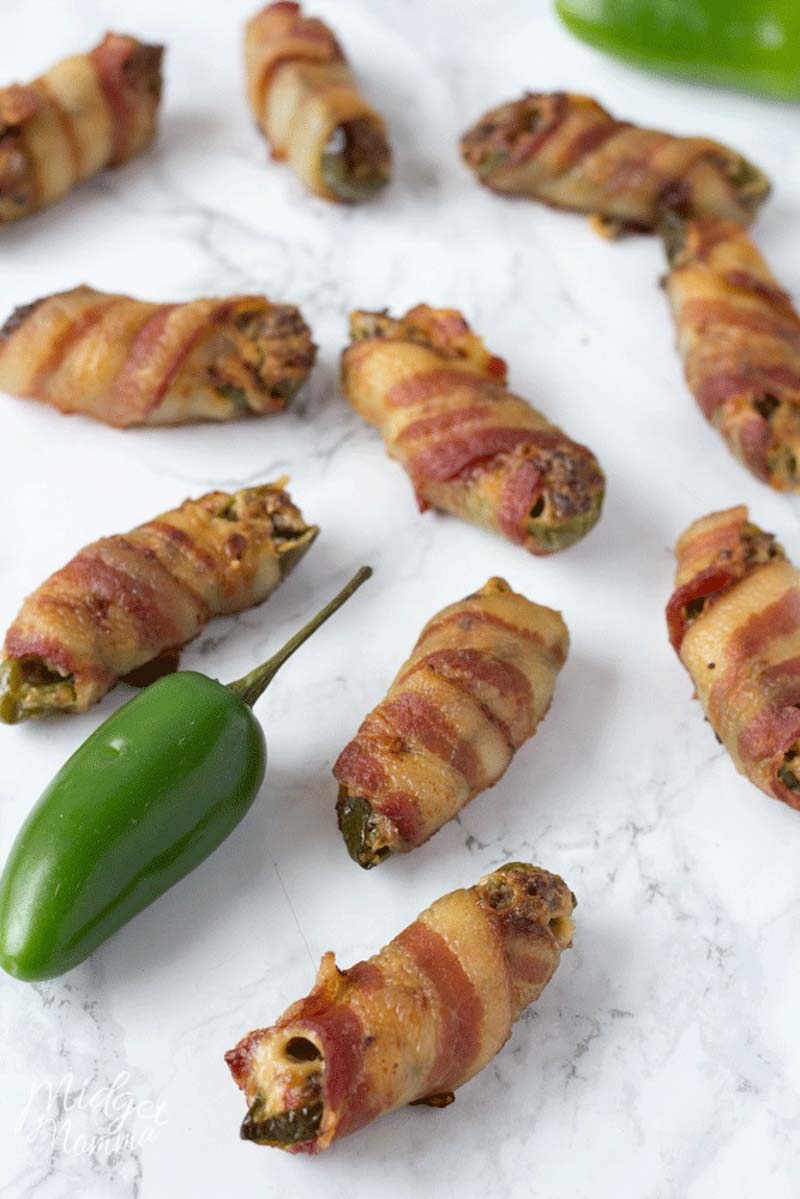 These easy stuffed bacon wrapped Jalapeno poppers are the perfect party appetizer. These oven baked Jalapeno poppers are full of flavor. With a mixture of cream cheese and sausage stuffed inside Jalapeno peppers then wrapped in bacon and baked in the oven these are the perfect appetizer to make! #Jalapeno #JalapenoPoppers #JalapenoPopper #JalapenoAppetizer Bacon Wrapped Stuffed Jalapenos