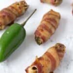 Jalapenos poppers stuffed with cream cheese and sausage wrapped in bacon