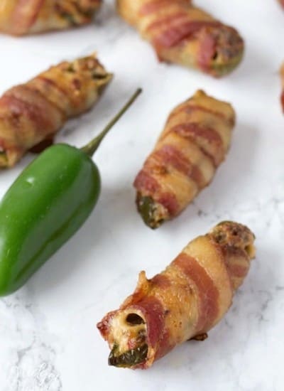 Jalapenos poppers stuffed with cream cheese and sausage wrapped in bacon