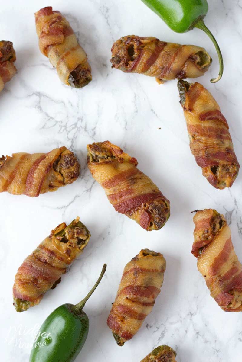 These easy stuffed bacon wrapped Jalapeno poppers are the perfect party appetizer. These oven baked Jalapeno poppers are full of flavor. With a mixture of cream cheese and sausage stuffed inside Jalapeno peppers then wrapped in bacon and baked in the oven these are the perfect appetizer to make! #Jalapeno #JalapenoPoppers #JalapenoPopper #JalapenoAppetizer alapeno poppers recipe wrapped in bacon and stuffed with cream cheese and sausage