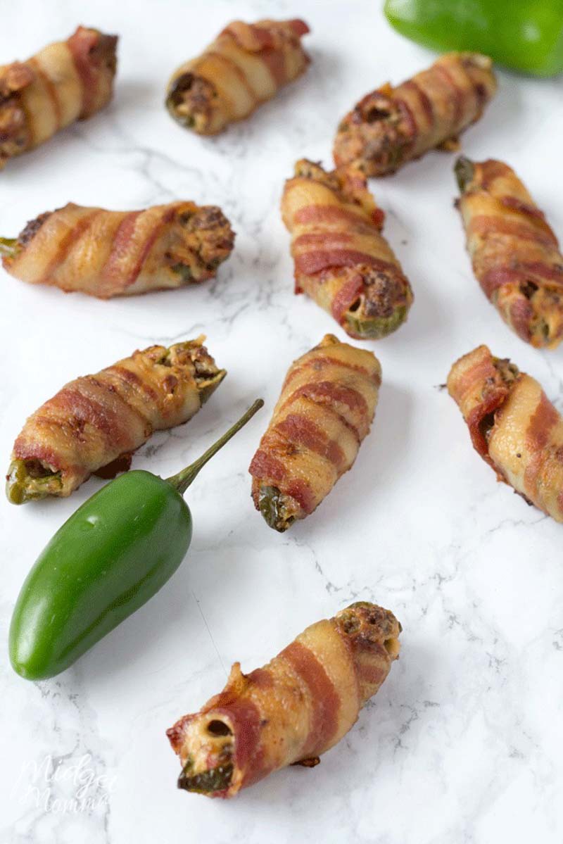 These easy stuffed bacon wrapped Jalapeno poppers are the perfect party appetizer. These oven baked Jalapeno poppers are full of flavor. With a mixture of cream cheese and sausage stuffed inside Jalapeno peppers then wrapped in bacon and baked in the oven these are the perfect appetizer to make! #Jalapeno #JalapenoPoppers #JalapenoPopper #JalapenoAppetizer Easy jalapeno poppers recipe