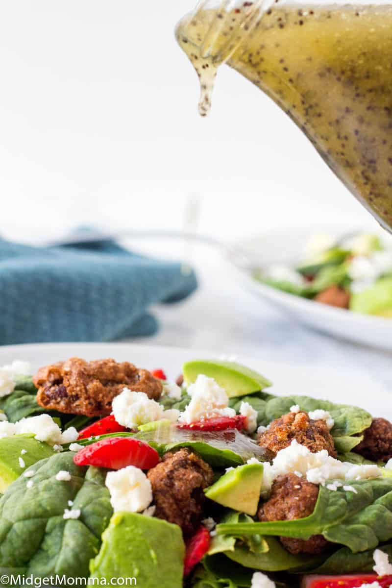 Poppy Seed dressing being poured over a salad