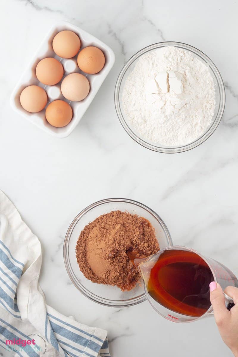 hot coffee being poured into a bowl of cocoa powder