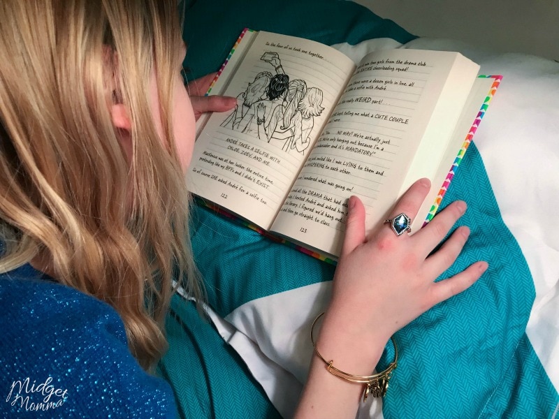 Teen girl laying in bed, reading a book.