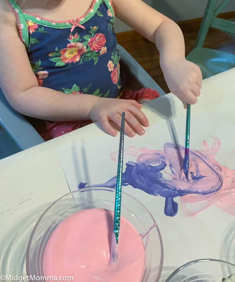 child painting with pink and purple puffy paint