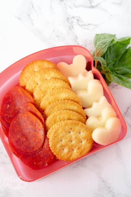 pizza crackers in a lunch box with mozzarella cheese, pepperoni and crackers