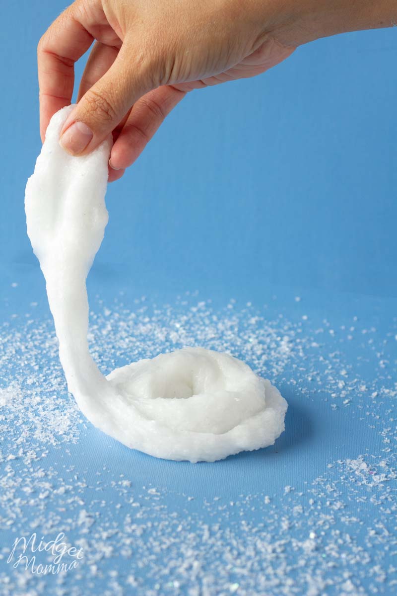 playing with snow slime on a table making a slime swirl