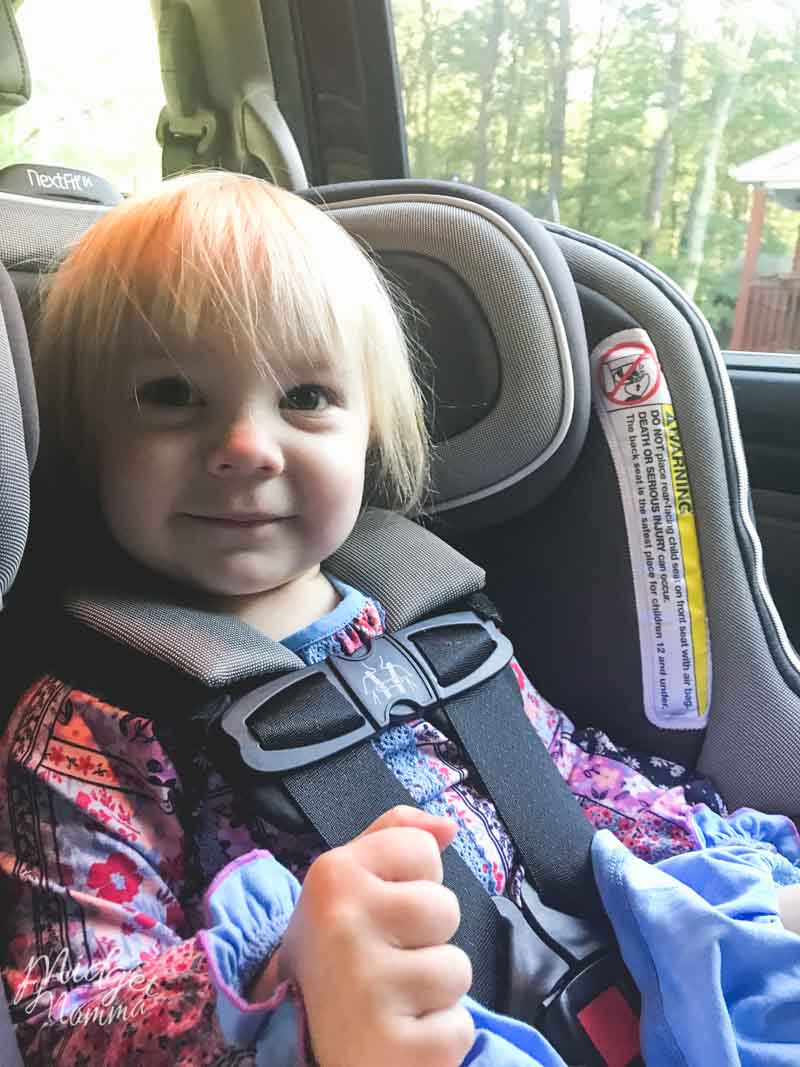 Child smiling and happy while sitting rear facing in the car age 2