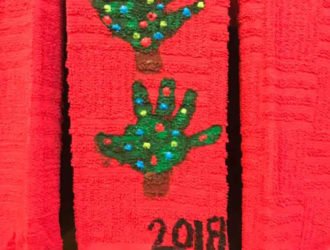 handprint Christmas Tree towel hanging on the stove door in the kitchen