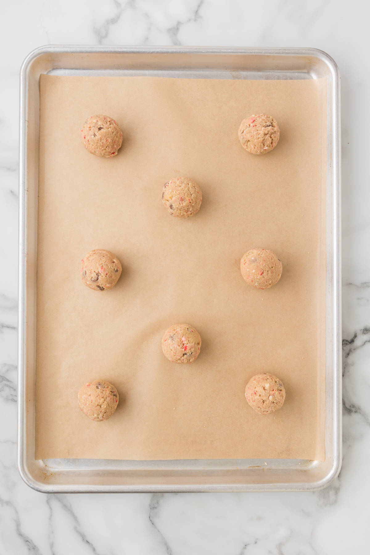 Cookie dough balls on a baking sheet.