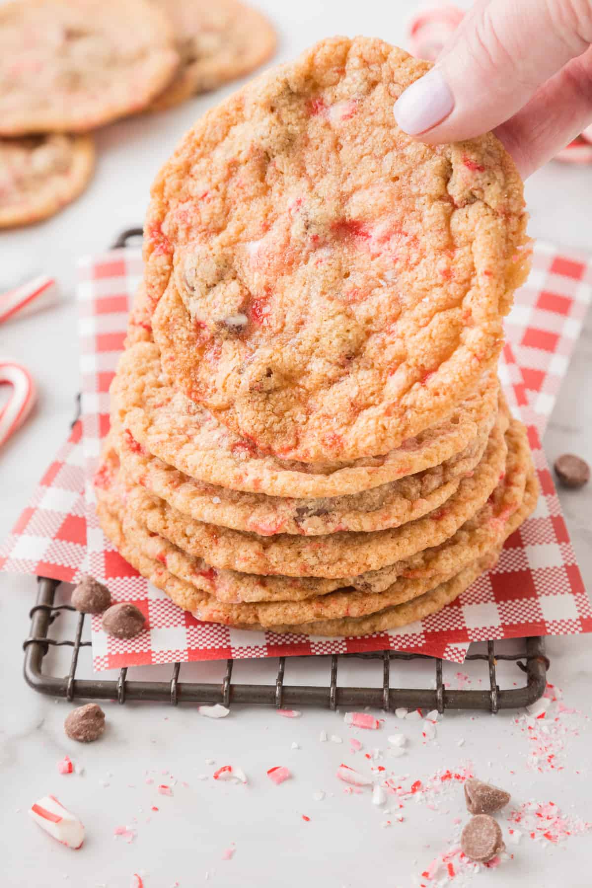 A stack of candy cane chocolate chip cookies on a cooling rack.