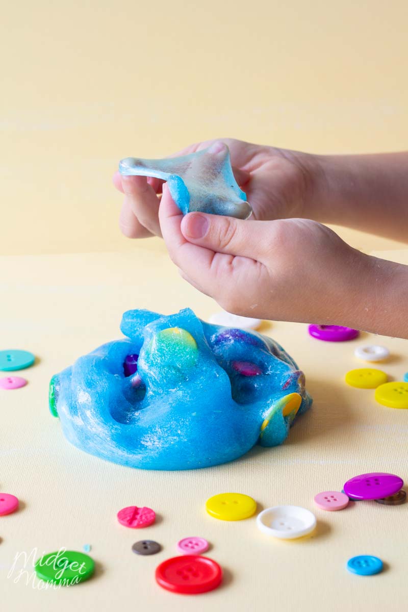 Kids hands playing with blue glitter slime 