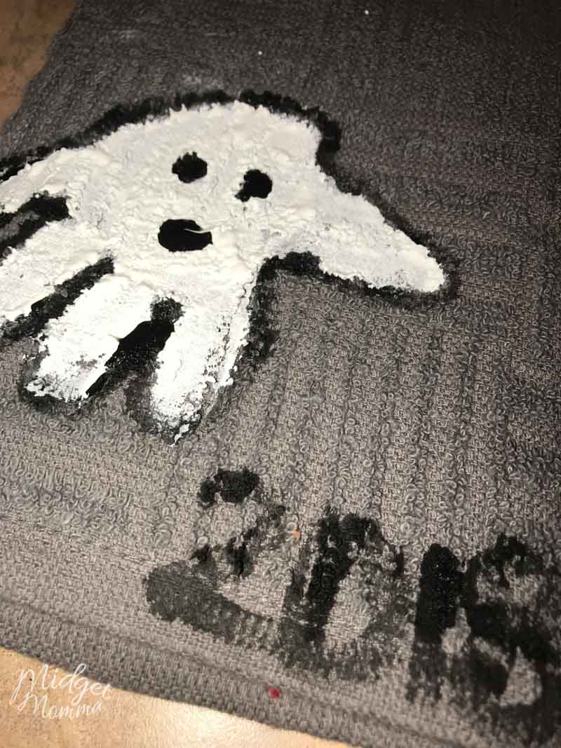 Halloween ghost handprint towel. Grey towel with kids hand print in white paint and black paint to make the eyes and mouth. 