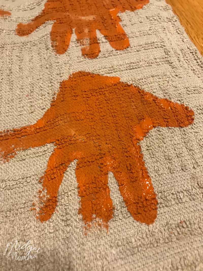 toddler handprint on a teatowel in orange paint