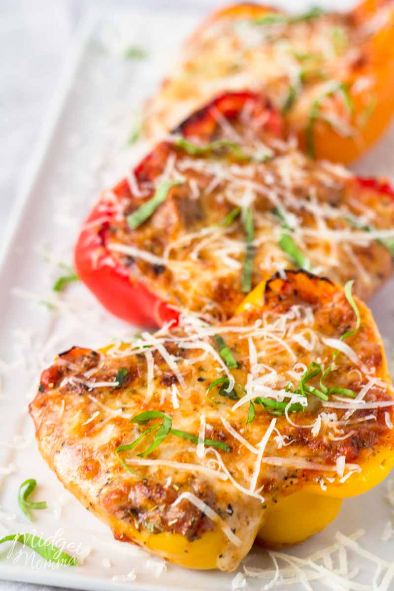 Cheesy Low Carb Lasagna Stuffed peppers using red and yellow peppers on a white serving dish