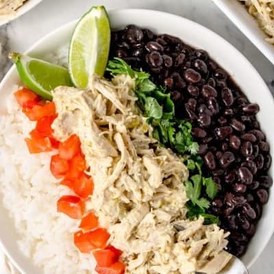 close up photo of a bowl of rice with Instant Pot Green Chile Chicken, tomatoes, black beans and cilantro