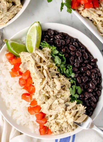 close up photo of a bowl of rice with Instant Pot Green Chile Chicken, tomatoes, black beans and cilantro