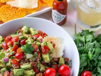 WOW Your family and friends with this amazing spicy avocado dip! A simple dip recipe, made with fresh ingredients including avocados and tomatoes. Perfect for taco night dinner or a game day snack! #SavorWinningFlavors #AvocadosFromMexico #HAVEARITA AND #FlavorYourWorld
