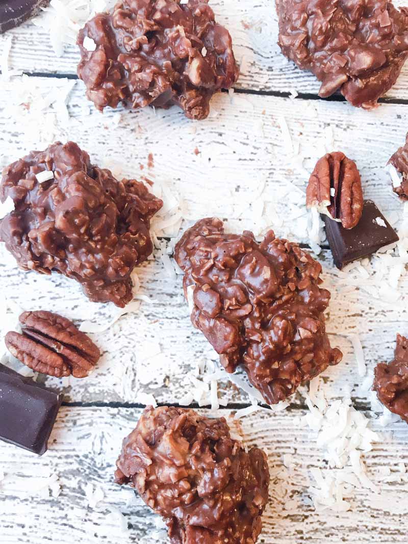 no bake low carb cookies with peanut butter, chocolate, pecans and toasted coconut set on a sheet.