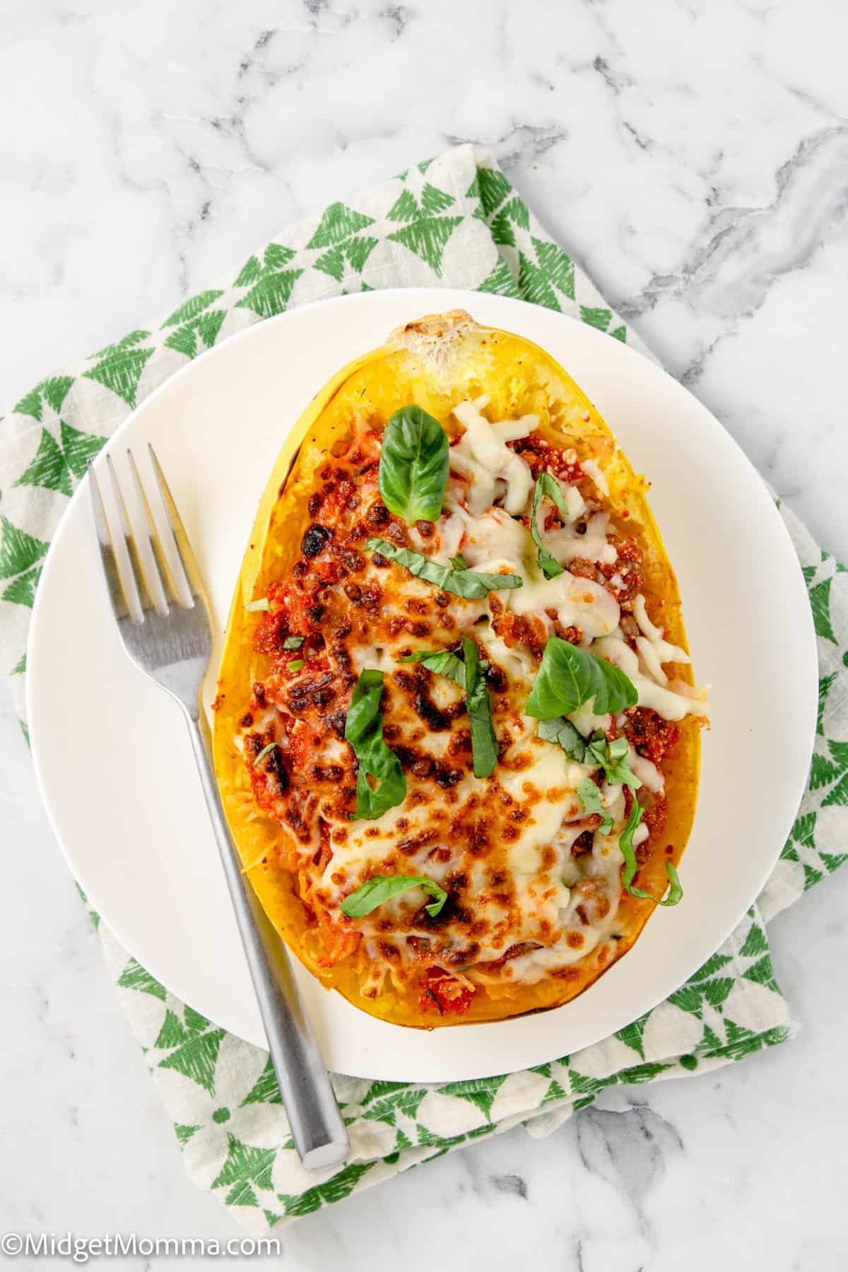 baked lasagna spaghetti squash on a white plate with a fork next to it