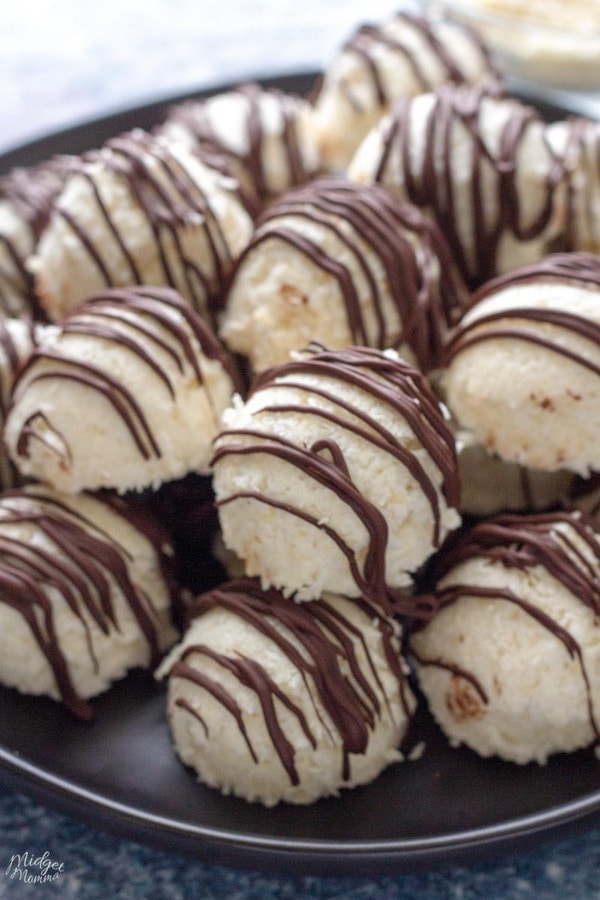 coconut balls on a plate drizzled with chocolate