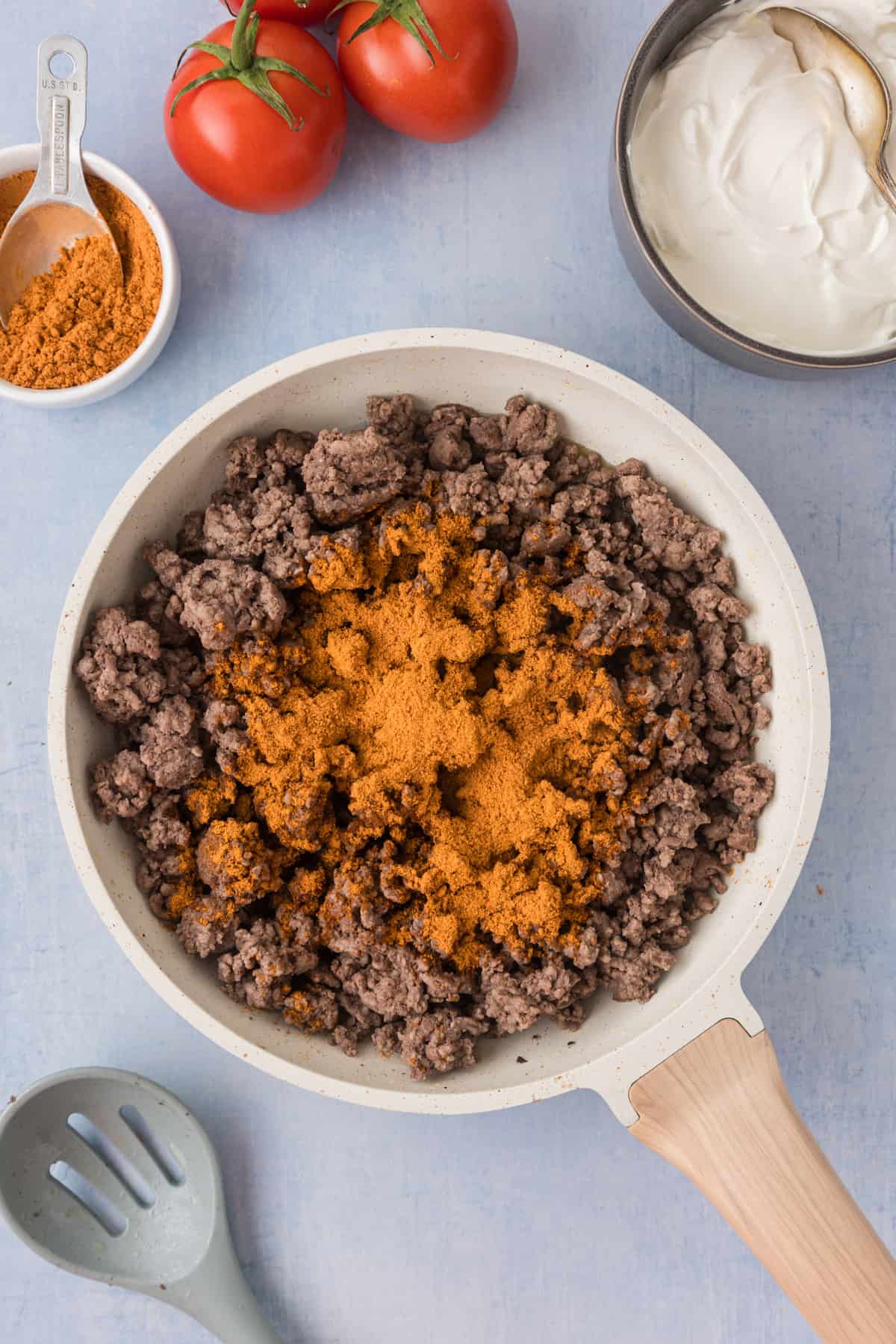 A frying pan with ground beef and spices.