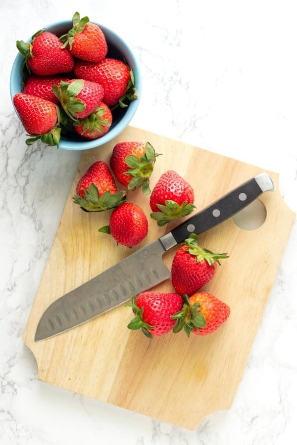 fresh strawberries on a cutting board to be cut to make low carb strawberry buttercream