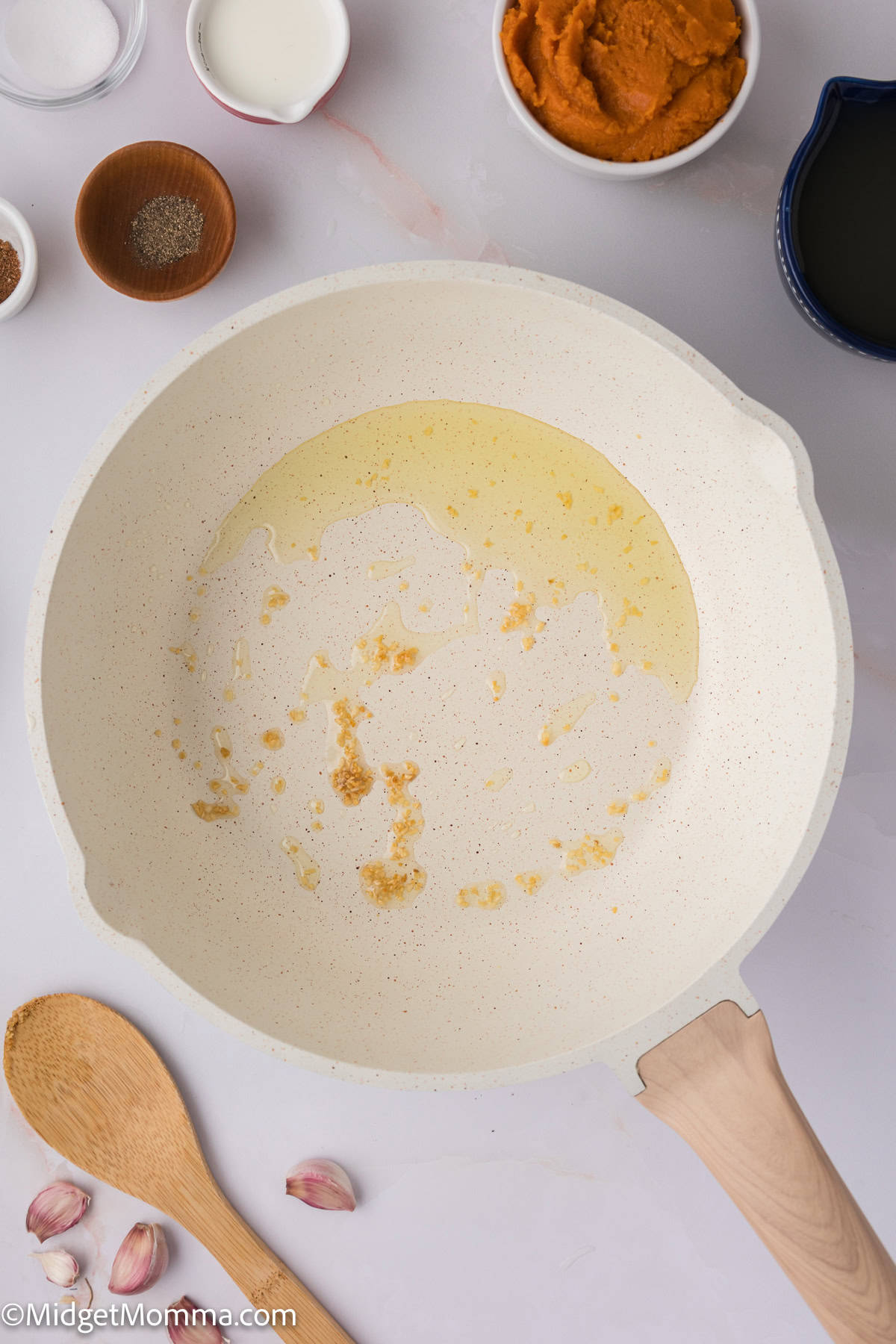 a skillet with minced garlic cloves and oil