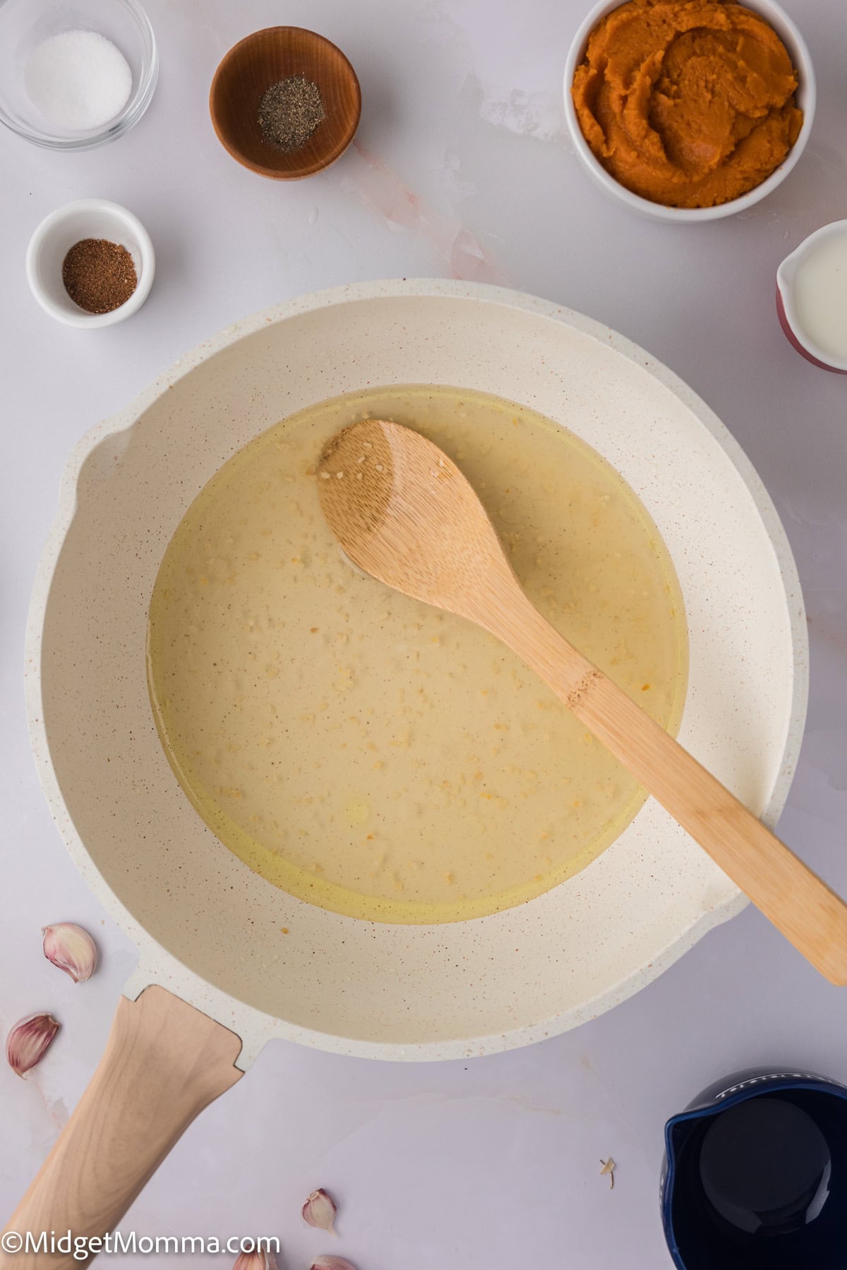 a skillet with minced garlic cloves and chicken broth