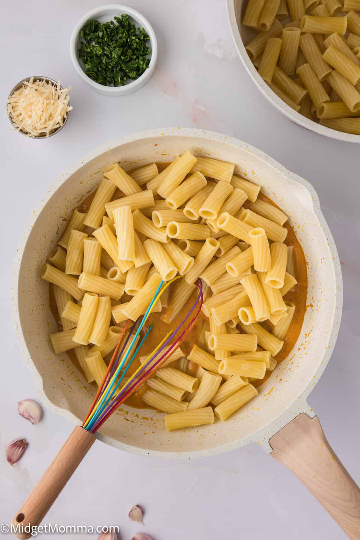 cooked pasta noodles being mixed with sauce