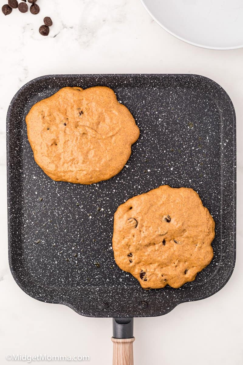 Pumpkin Chocolate Chip Pancakes cooking on a griddle