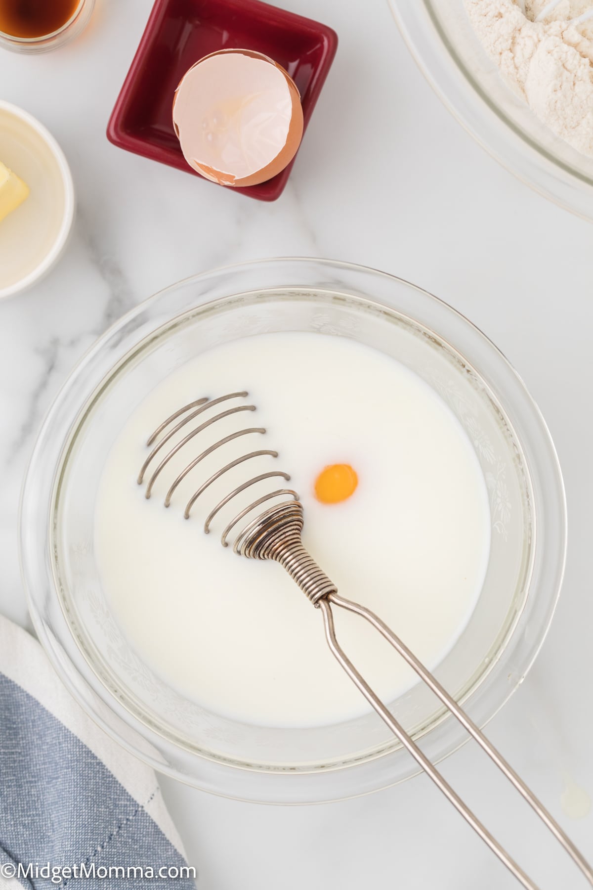 egg and milk for The Best Fluffy Homemade Pancakes Recipe being mixed together in a bowl