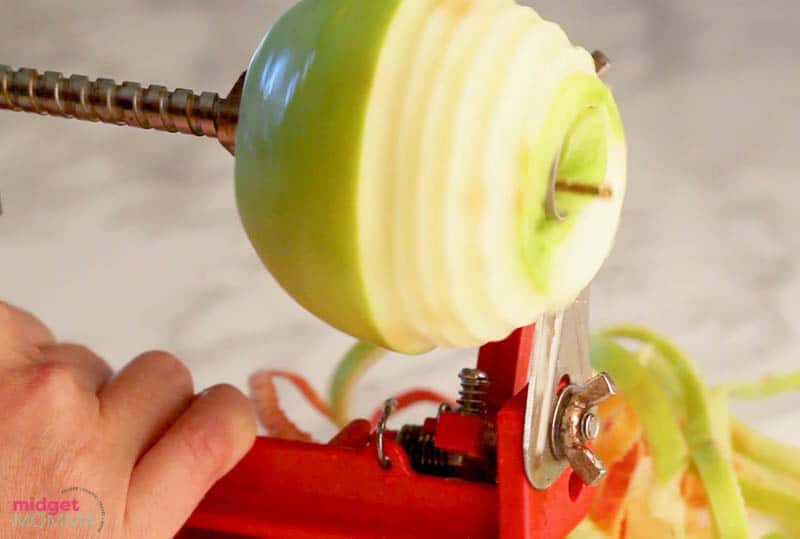 apple being peeled on an apple peeler
