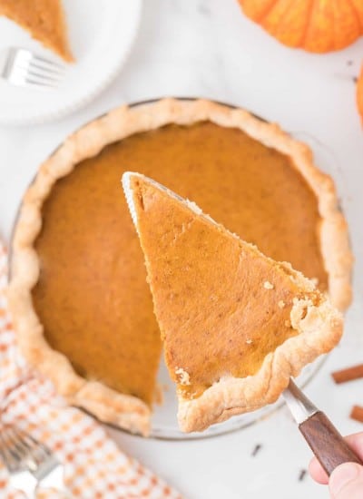 Slice of simple pumpkin pie recipe on a pie serving utensil.