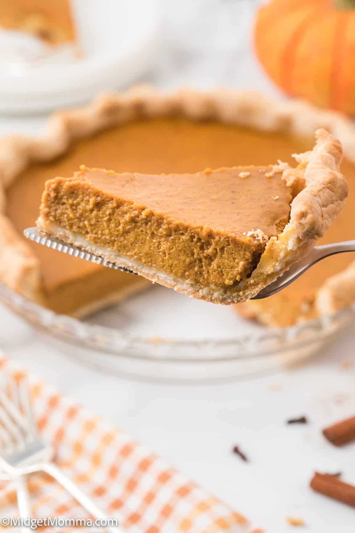 Side view of a slice of pumpkin pie on a pie serving utensil