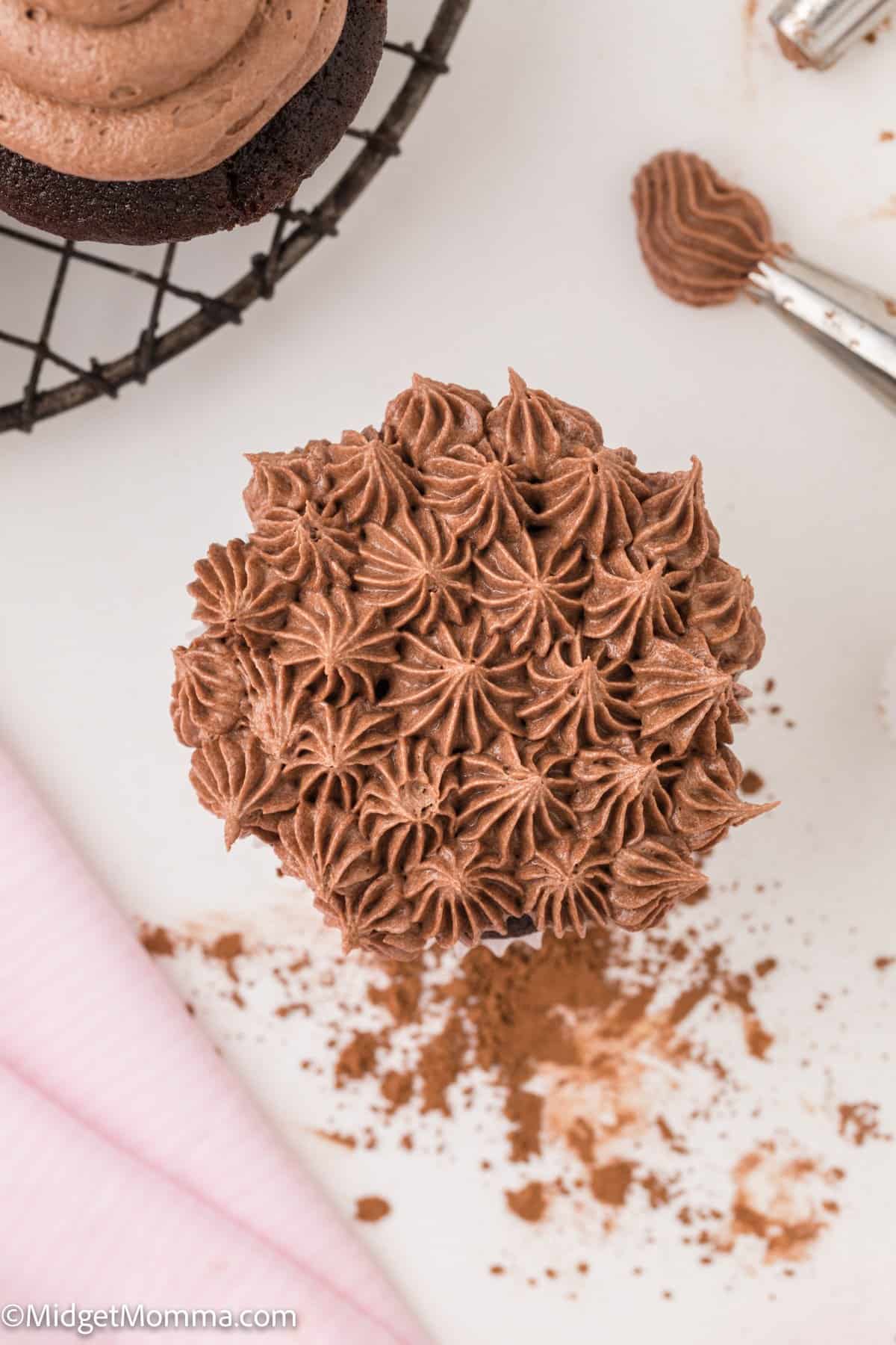 overhead photo of chocolate buttercream frosting piped on to a chocolate cupcake.