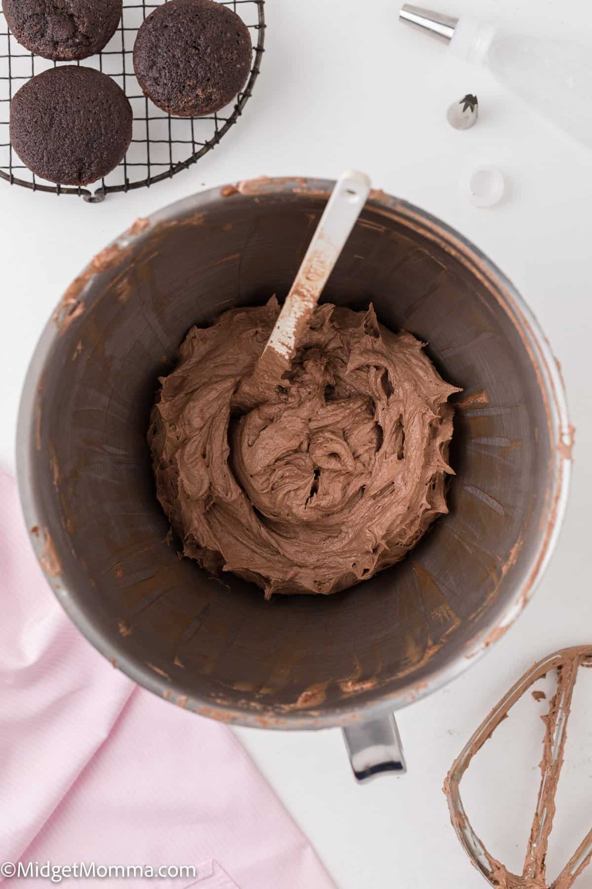 finished bowl of chocolate buttercream frosting in the bowl of a stand mixer.