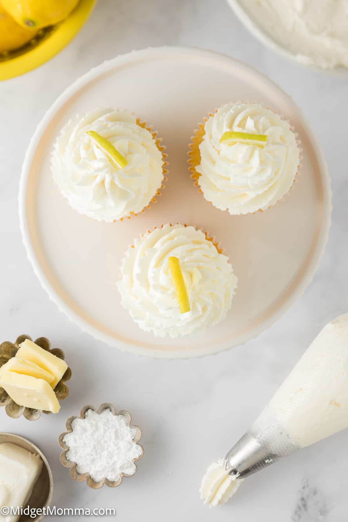 3 cupcakes topped with buttercream on a plate - overhead photo