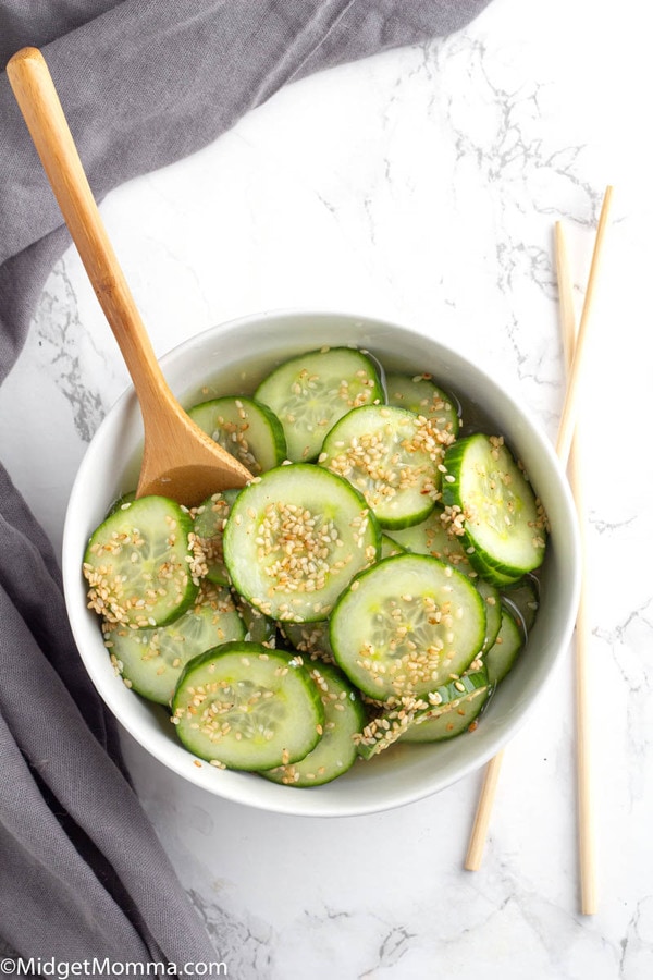 Asian Cucumber Salad in a bowl with a wooden spoon