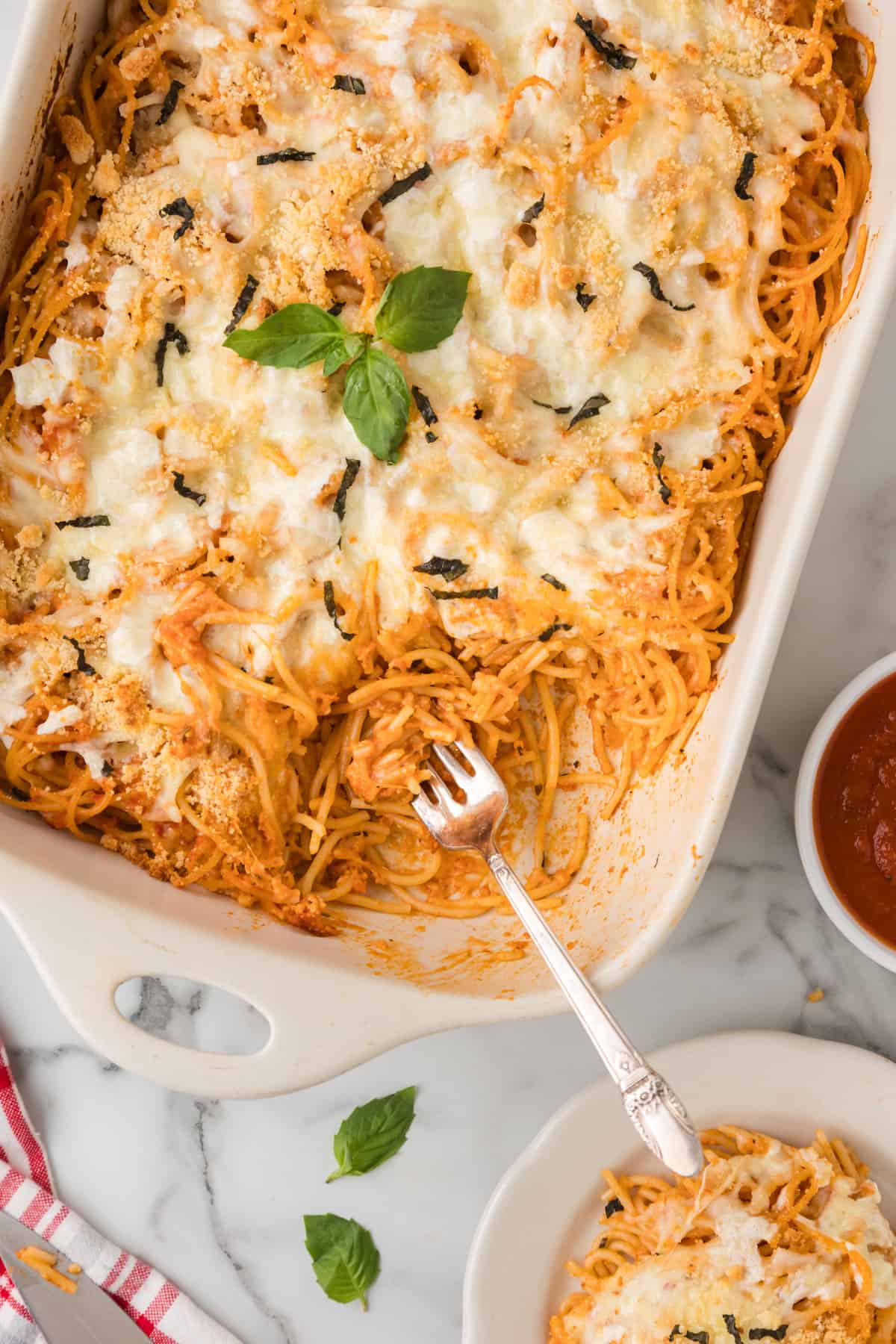 baked Spaghetti casserole in a white dish with a fork.