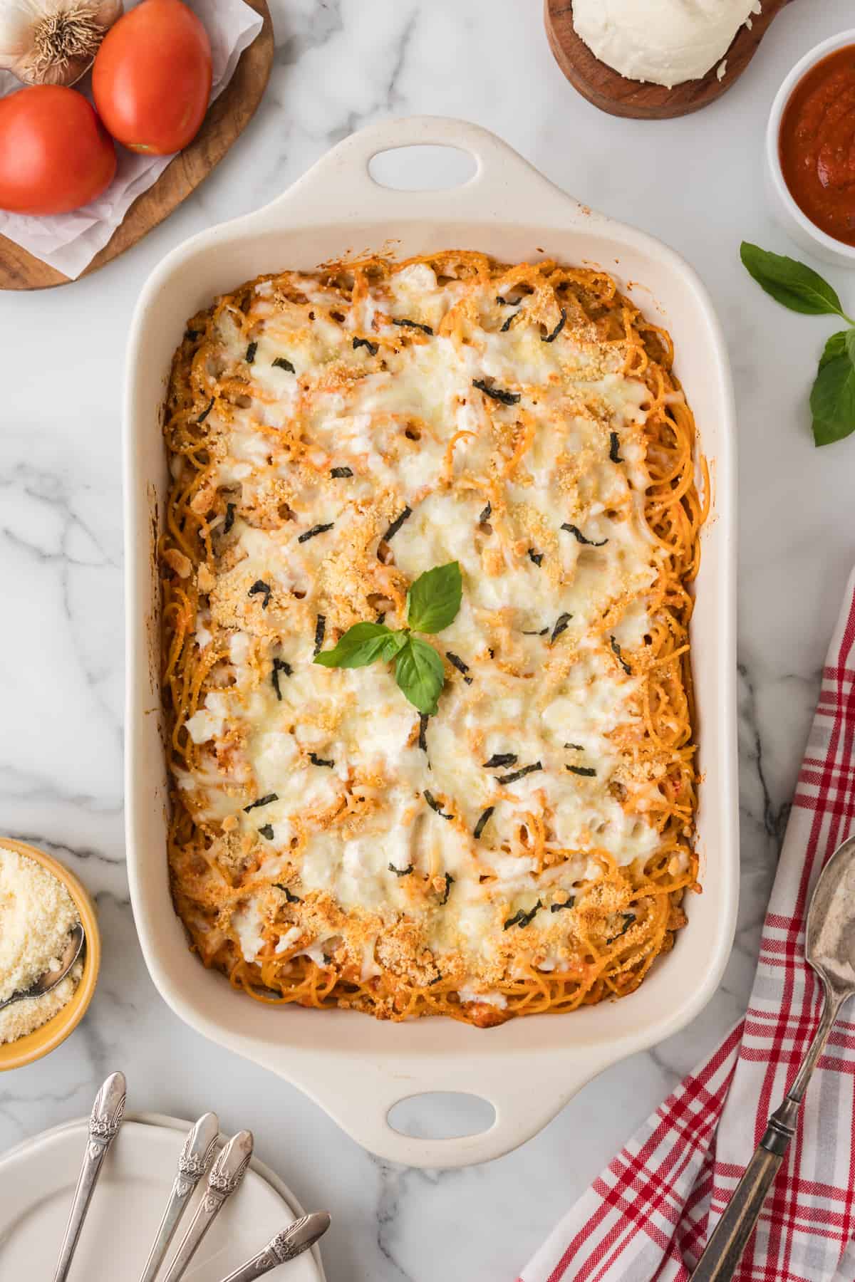 baked Spaghetti in a white casserole dish with a fork.