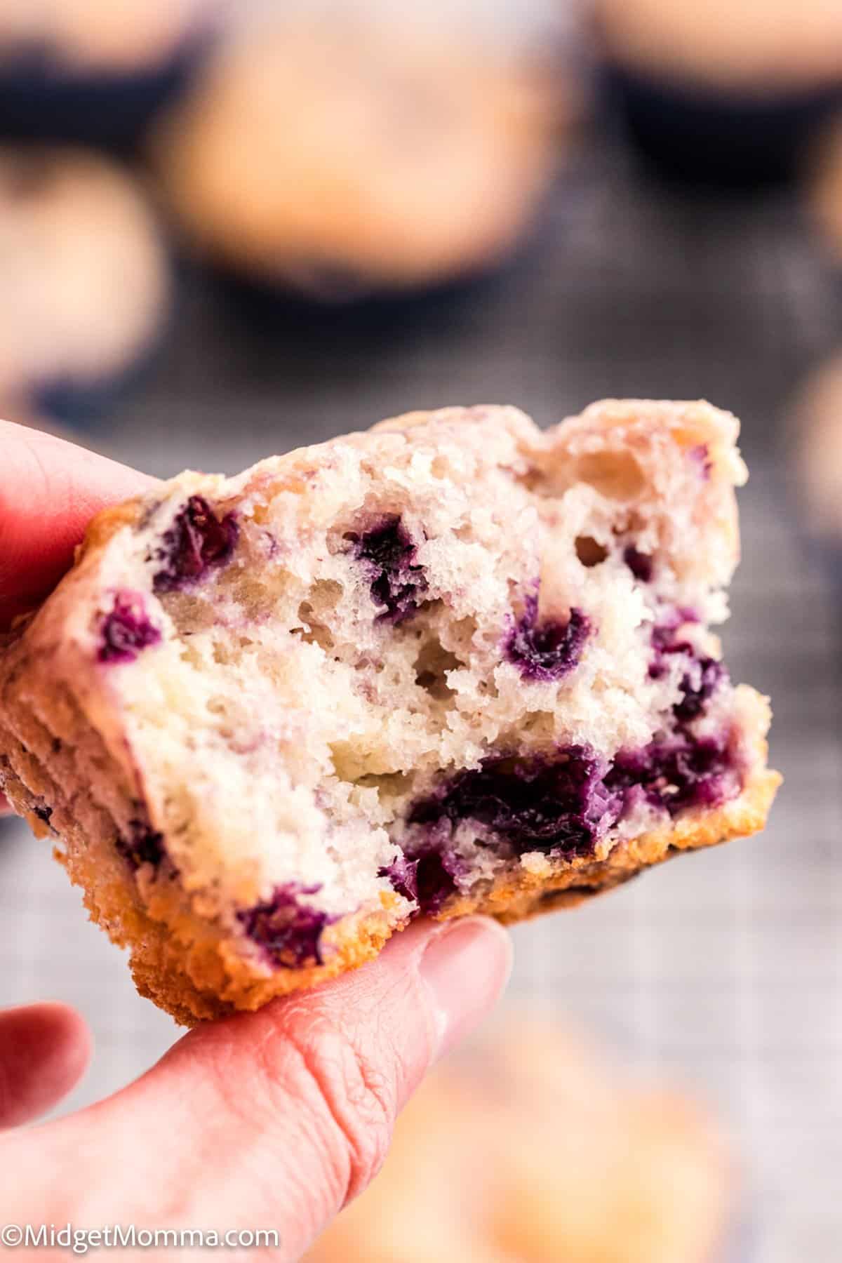 hand holding half of a Greek Yogurt Blueberry Muffin