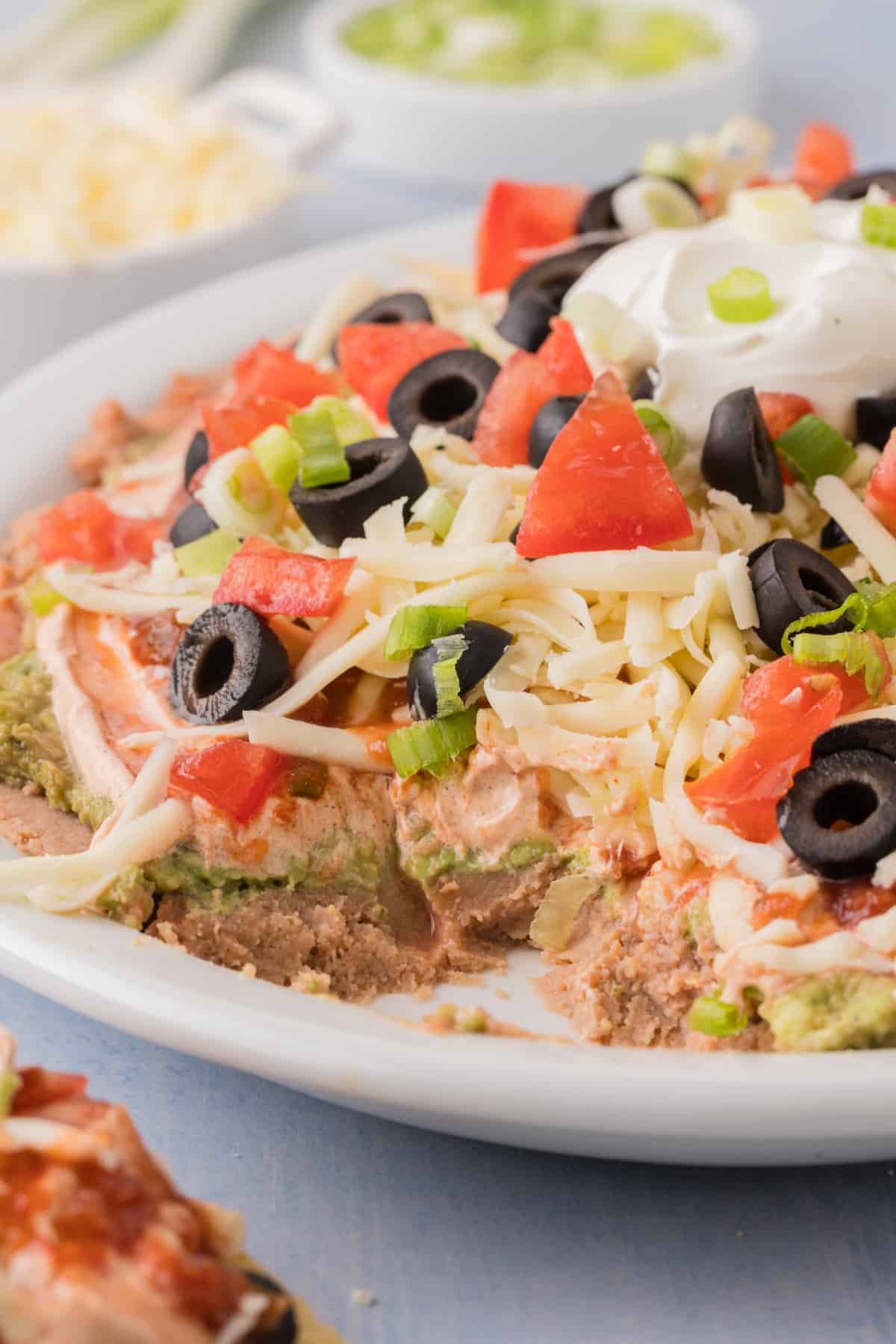 a serving dish filled with 7 layer mexican taco dip