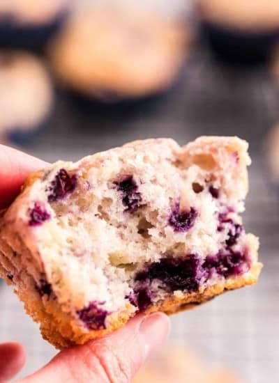 hand holding half of a Greek Yogurt Blueberry Muffin