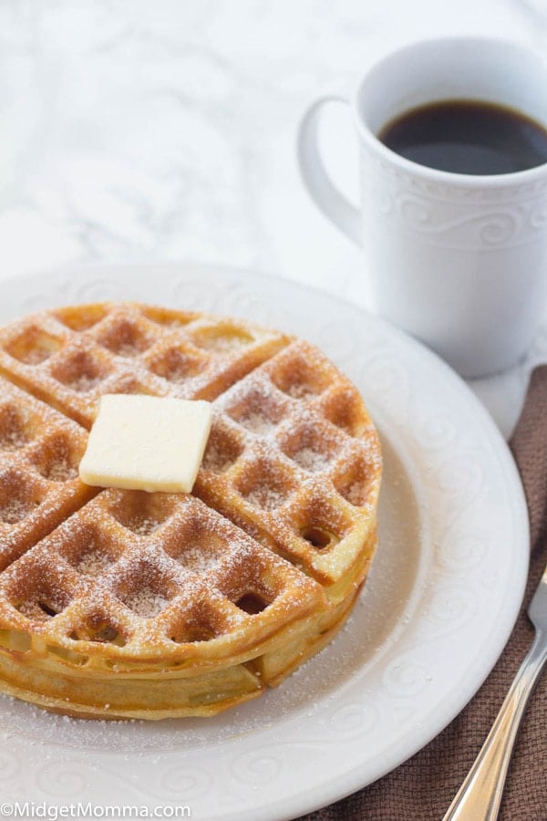 Easy Belgian Waffles Recipe stacked on a plate with butter and a cup of coffee