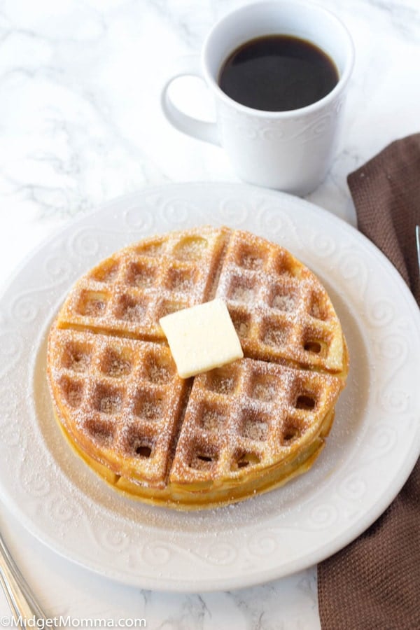 How to Make Belgian Waffles Recipe - 2 belgian waffles on a white plate topped with powdered sugar and butter 